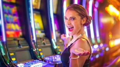 Young happy woman at a casino playing with slot machines