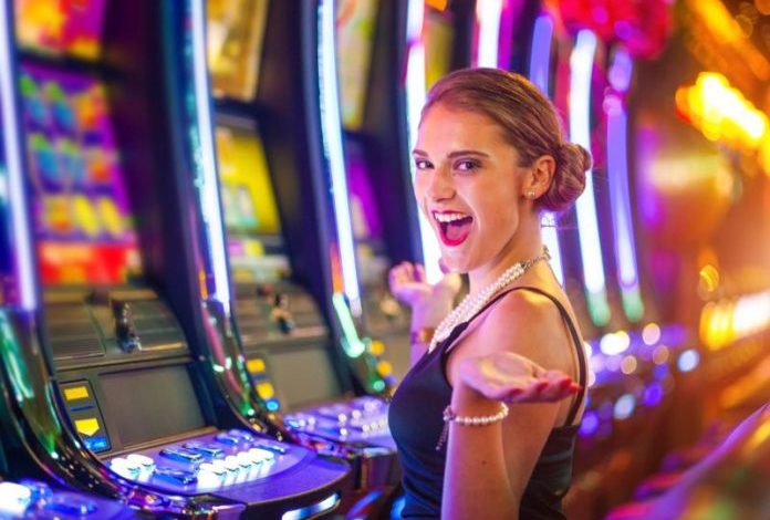 Young happy woman at a casino playing with slot machines